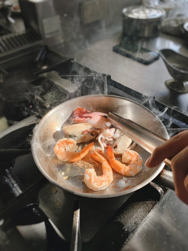 Close-up of shrimp being cooked in a sizzling pan